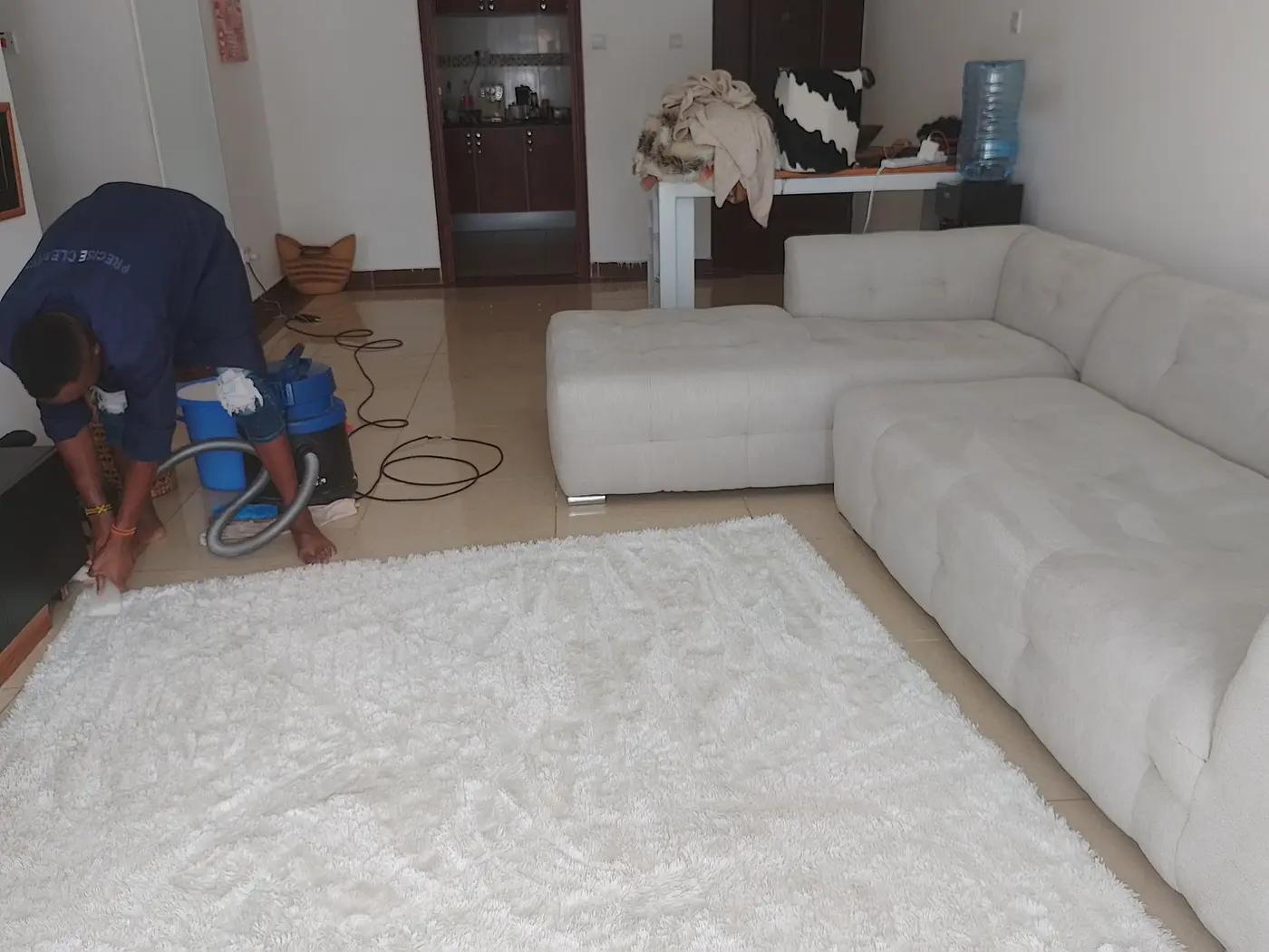 PrimeMax technician deep cleaning upholstery and a carpet in a Nairobi home
