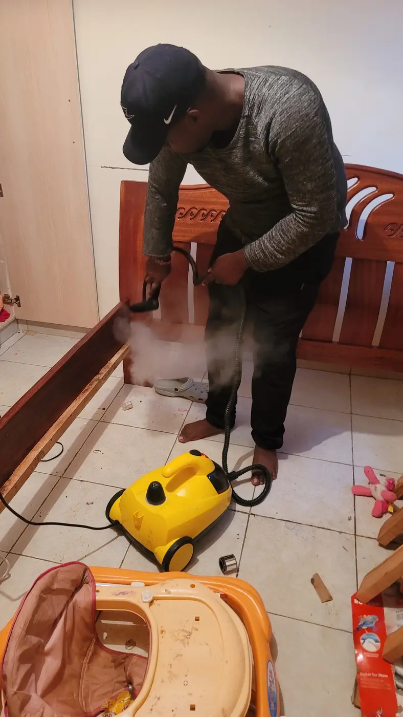 PrimeMax technician steam-treating a wooden bed frame for bedbugs