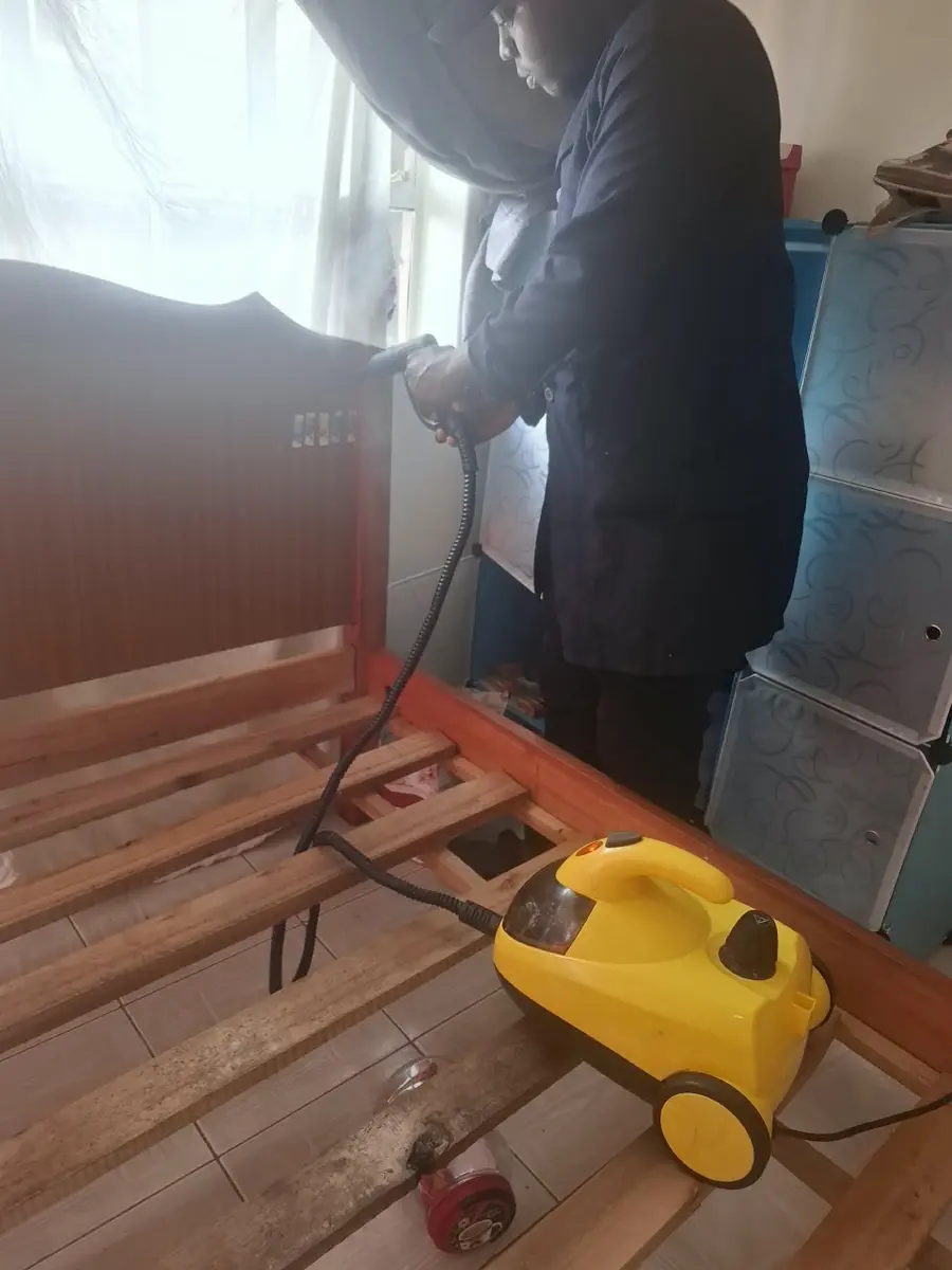 PrimeMax steam-treating a wooden bed frame during bedbug treatment