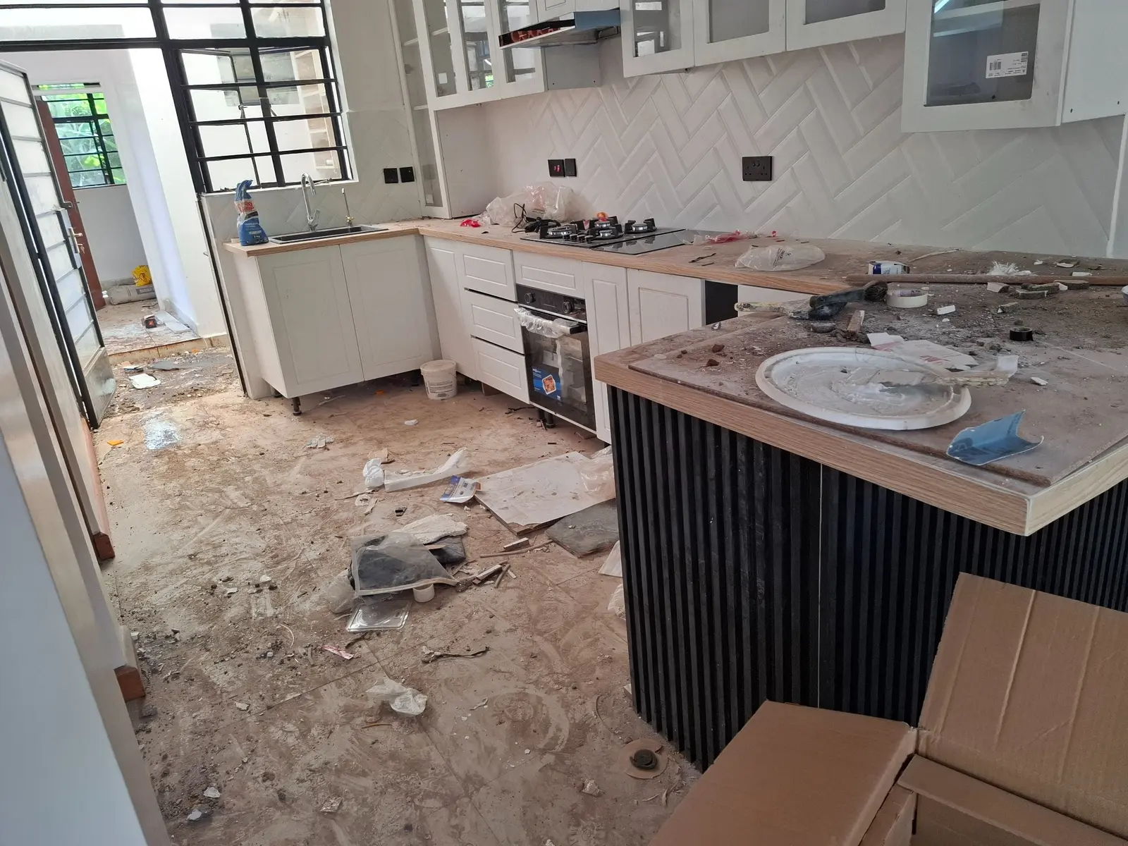 New kitchen covered in construction dust and debris before cleaning